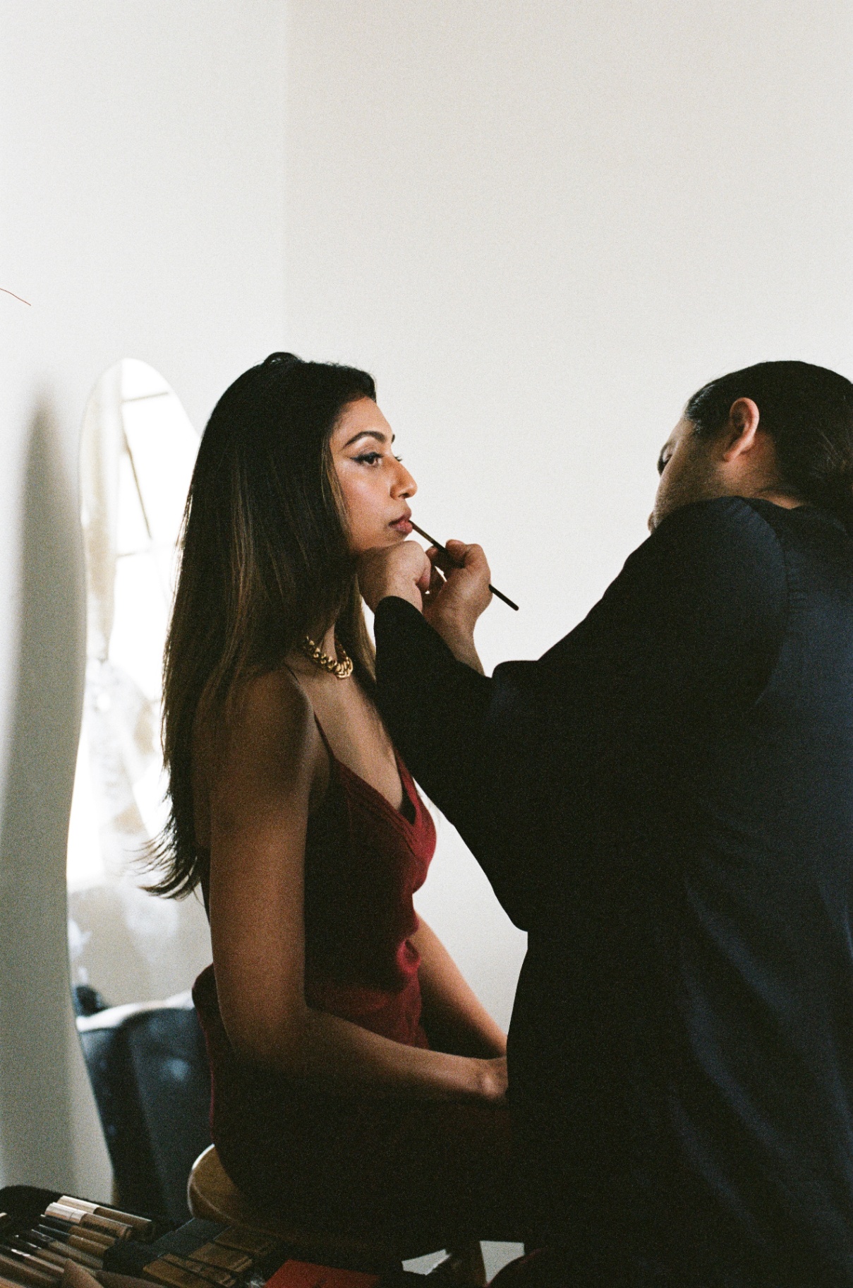Carwin Brice applying lip color on model in red